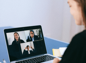 Business team collaborating around a laptop using Phoneserv cloud phone system for seamless communication and productivity